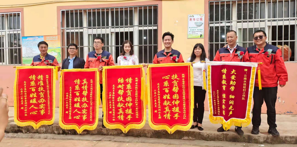 老隊員手捧落紅甸村各界人士贈送錦旗合照.jpg